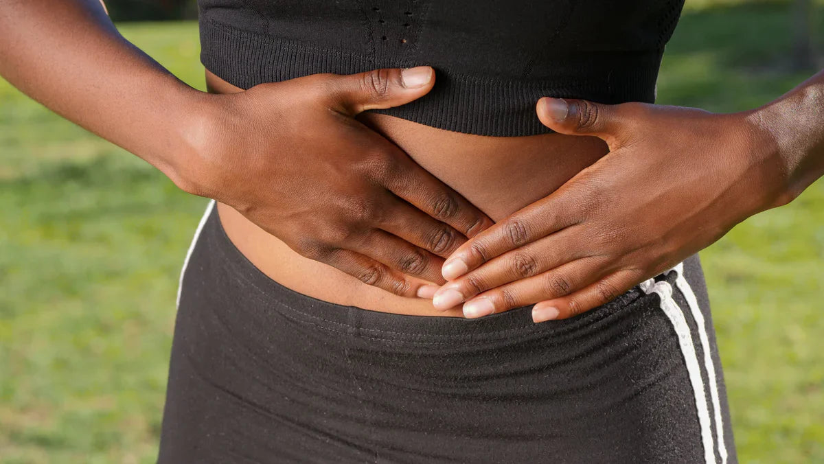 Une femme souffrante se tient le ventre